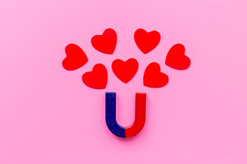 Love and relashionship concept. Horseshoe magnet with heart shapes