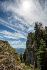 View on coniferous woods and Rocky mountains in Bulgaria with cross on top of it.