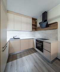 Modern interior of new beige kitchen with oven. Wooden shelves.