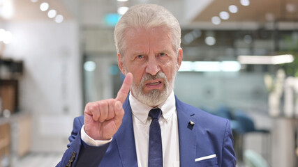 Portrait of Old Businessman saying No with Finger Gesture 