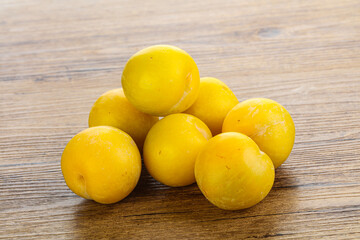 Ripe sweet yellow plum heap over background