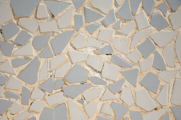 Mosaic of broken ceramic pieces in white and blue Valencian trencadís style.