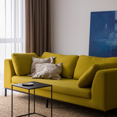 Modern yellow sofa in bright living room, close-up
