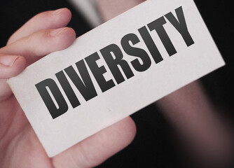 Diversity word on a card in businessman hand. Social concept. No to discrimination at workplace.