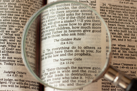 Christian golden rule. Second great commandment. Treat others as you want to be treated. Jesus Christ's teaching of relationship.Magnifying glass over open Holy Bible Book. A closeup. Biblical concept