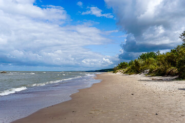 beautiful empty sand beach on the Baltic Sea in Latvia with forest and a blue sky