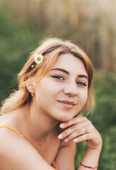 Fototapeta premium Young beautiful girl with chamomile flower in her hair