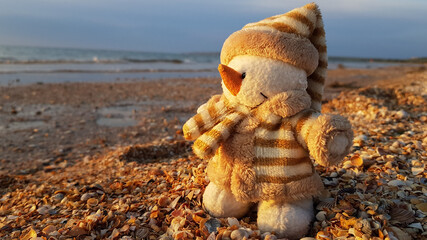 snowman figurine on the beach. winter holidays in warm countries. Christmas on the beach by the sea.