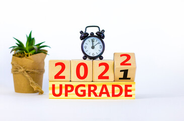 Symbol of planning 2022 upgrade new year. Alarm clock. Turned a wooden cube, changed words 'upgrade...