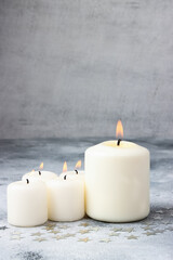 White burning candles on concrete background. Christmas and New Year decoration