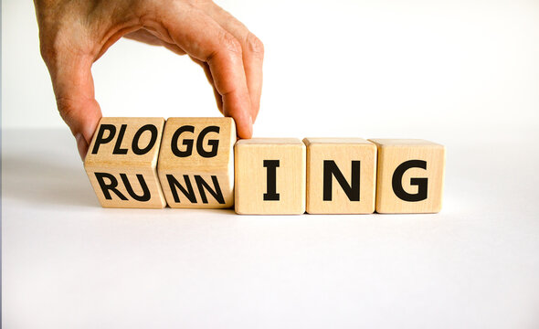 Running or plogging symbol. Runner turns wooden cubes and changes the word running to plogging. Beautiful white table, white background, copy space. Sports, ecological, running or plogging concept.