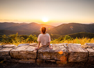View of woman sees sunset over blue ridge mountains from skyline drive in Shenandoah National Park,...