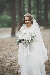 Beautiful bride posing in wedding dress outdoors