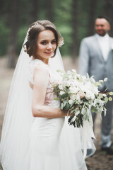 Beautiful romantic wedding couple of newlyweds hugging in park on sunset