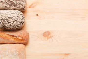 Bread, pastries on a light wooden background. Bread with sesame seeds and seeds, bread texture. Delicious flavored bun. Lots of airy fresh bread.