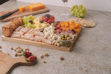 Obraz na płótnie Canvas cheese platter on a marble table with fruit and wine