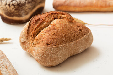 Bread, pastries on a light background. Bread with sesame seeds and seeds, bread texture. Delicious flavored bun. Lots of airy fresh bread.