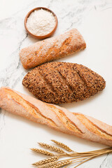 Bread, pastries on a light background. Bread with sesame seeds and seeds, bread texture. Delicious flavored bun. Lots of airy fresh bread.