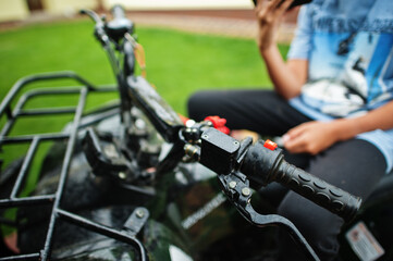 Fototapeta na wymiar Boy in four-wheller ATV quad bike with mobile phone.