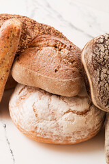 Bread, pastries on a light background. Bread with sesame seeds and seeds, bread texture. Delicious flavored bun. Lots of airy fresh bread.