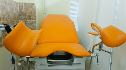 an orange gynecological chair in the medical office.