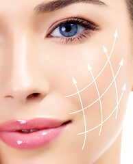 Pretty woman with massage lines on her face showing facial lifting effect on the skin.