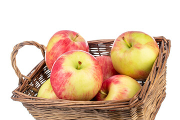 Several juicy organic apples with a basket, close-up, isolated on white.