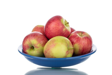 Several juicy organic apples with ceramic utensils, close-up, isolated on white.