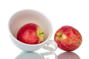 Two ripe organic apples in a ceramic dish, close-up, isolated on white.
