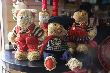 Group of dolls seated at the entrance of a warehouse table with costumes and Christmas theme. Christmas stock photo. Christmas Decoration