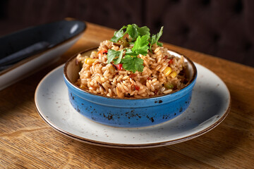 delicious healthy vegan Risotto with Sweet Corn, red bell pepper on plate on wooden table, close-up