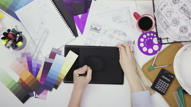 Top view of a creative designer using a graphic tablet while working at his desk
