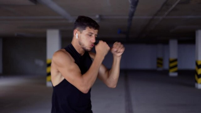 Boxer does shadow boxing in underground parking