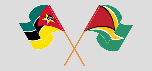 Crossed and waving flags of Mozambique and Guyana