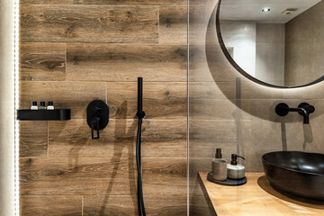 Part of the modern wooden tiled bathroom in beige and brown warm colors. 