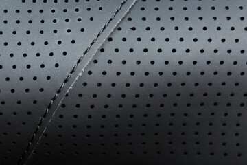 Close-up full-screen black textured leather with perforations