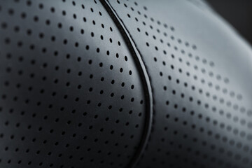 Close-up full-screen black textured leather with perforations