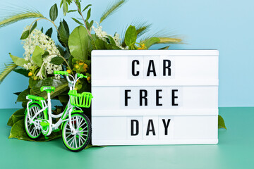 Toy bicycle and lightbox with text car free day. World bicycle day, environment protection, sustainable lifestyle concept with copy space