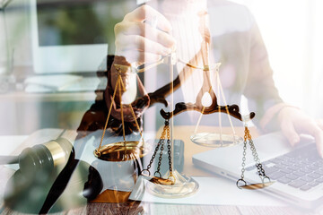 Justice and law concept.Male judge in a courtroom with the gavel, working with, computer and docking keyboard, eyeglasses, on table in morning light