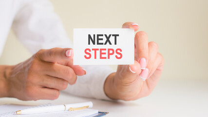'next steps' card in the woman's hands. Business, Ethics, Advertising, Marketing.