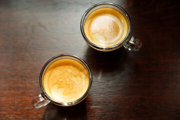 two glass coffee cup with espresso near the window in morning on dark background