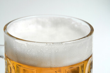 Mug of beer with foam on white background close up