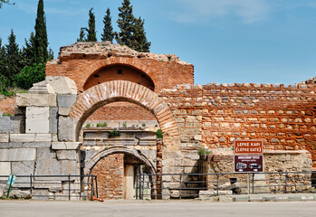 One of the entrance gate of ancient city of iznik (nicaea) made of red bricks stones city walls and stairs by taken photo during sunny day and ancient architecture arch and sky low angle photo.