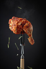 Hot chicken drumstick on a fork.