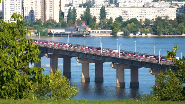 View of the Paton Bridge with Movement of Cars and Trucks on the City Road in Time Lapse. Lot of Cars, Public Transport in Peak Hour. Bridge During Reconstruction