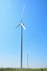 Fototapeta premium Field with huge wind generators against the blue sky