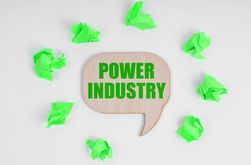 On a white background, there are crumpled green pieces of paper and a wooden sign with the inscription - Power Industry