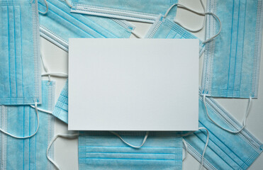 blue protective masks, white rectangular card with space for text, photo from above