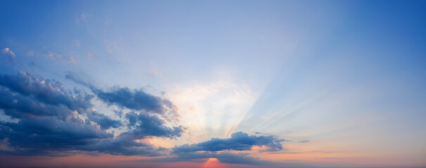 Fototapeta na wymiar Sunset sky with rays of sun shining through the clouds.