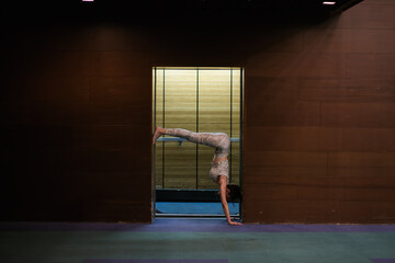 woman practicing yoga in front of elevator